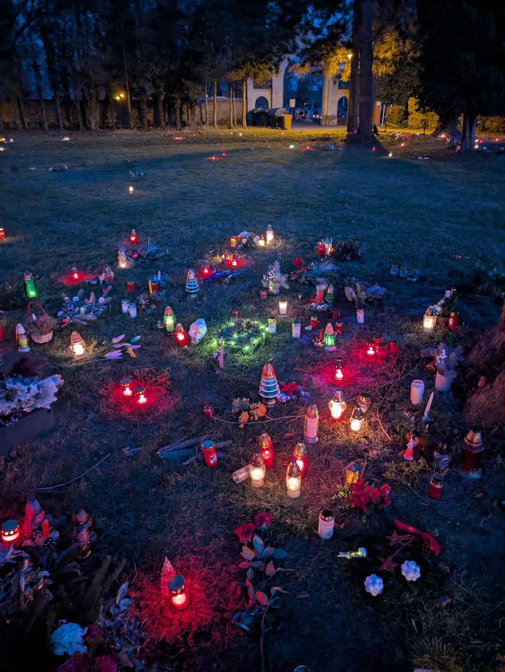 A collection of lit candles at a cemetery